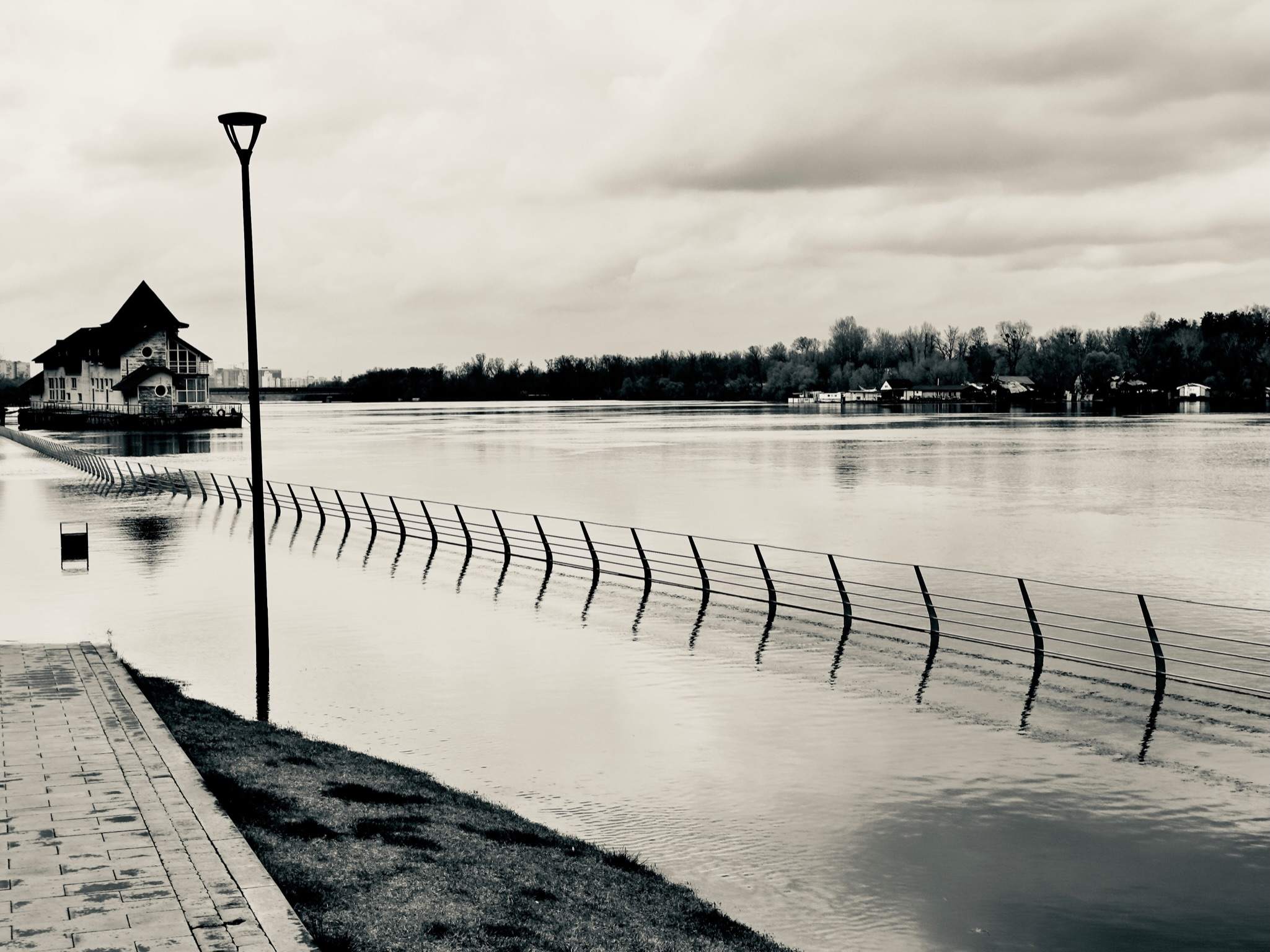 Загорожа вздовж води й ліхтар, чорно-біле