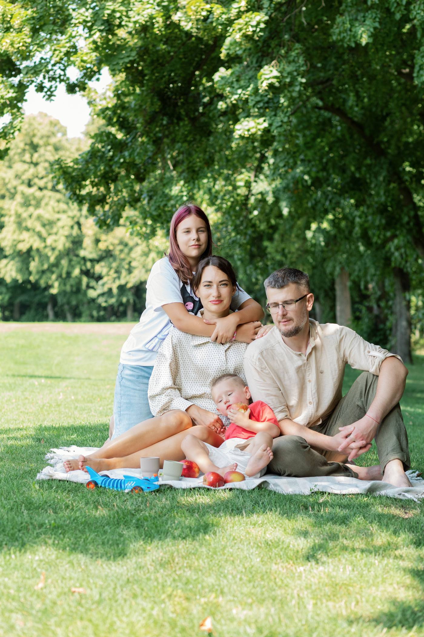Родина на пікніковій ковдрі серед трави